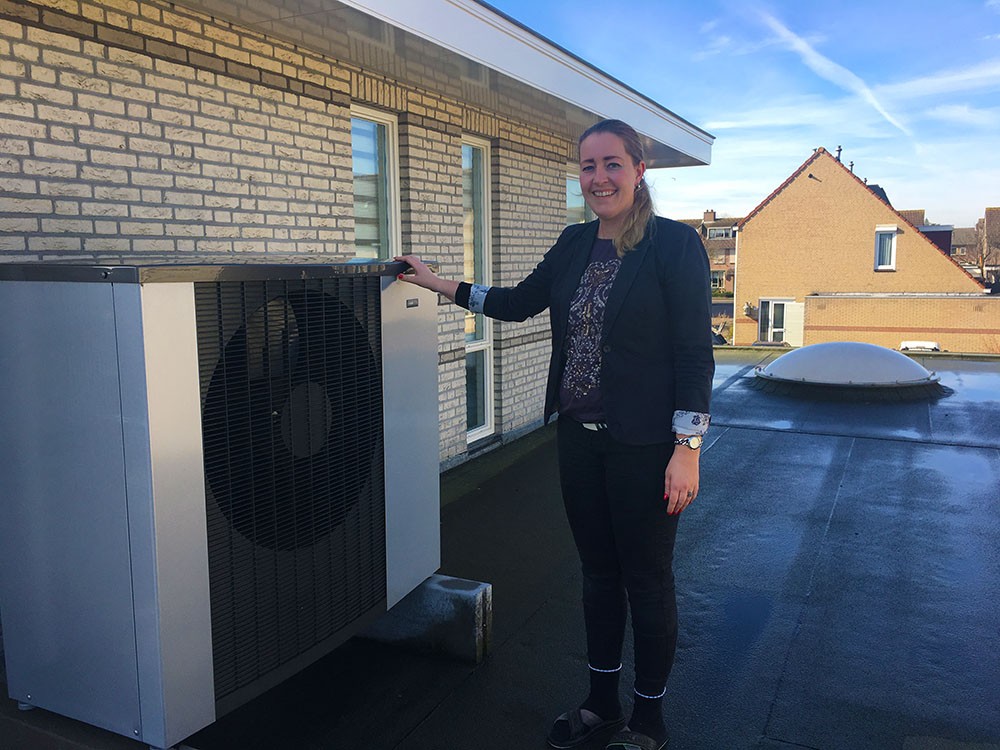 Desiree Kon naast de NIBE F2120 lucht/water warmtepomp op haar dak Desiree Kon naast de NIBE F2120 lucht/water warmtepomp op haar dak