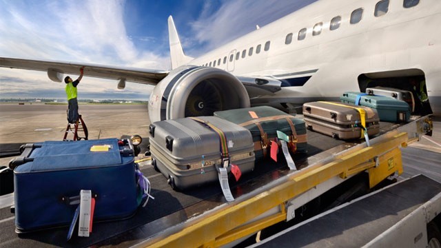 Bagage in een vliegtuig laden Koffers op de kofferband gaan een vliegtuig in